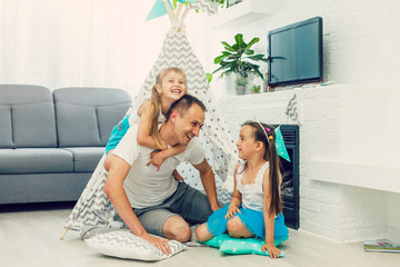 Happy dad carrying two little cute child girl on back giving kid piggyback ride having fun...