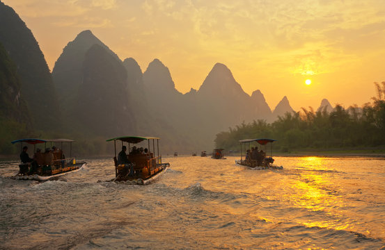 Li (Lijiang) River With Karst Hills. All Arriving Tourists Should Take River Trips On Traditional Bamboo Rafts In The Evening At Sunset. Unusual Natural Park. Tourism In Beautiful Places In China