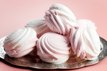 Delicate white and pink marshmallow or zephyr. Silver plate of strawberry vanilla marshmallow on pale pink background.