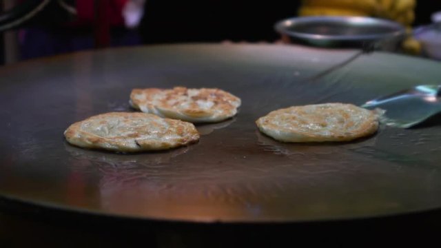 Close up of Thai roti fried on pan, slow motion