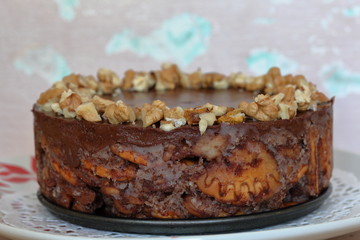 Cake without baking cookies and chocolate. Decorated with walnut crumbs. On a shabby aged background.