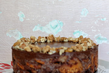 Cake without baking cookies and chocolate. Decorated with walnut crumbs. On a shabby aged background.