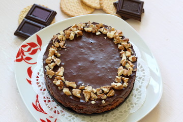 Cake without baking cookies and chocolate. Decorated with walnut crumbs. On a shabby aged background.