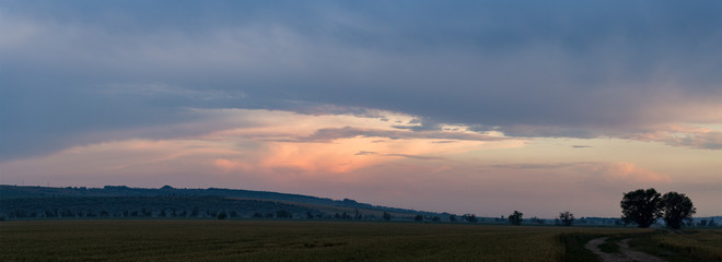 Leaden, storm clouds covered the sunset. Cumuliform cloudscape on blue sky. The terrain in southern Europe. Fantastic skies on the planet earth. Tragic gloomy sky.	Panorama.