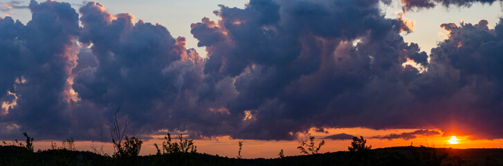 Leaden, storm clouds covered the sunset. Cumuliform cloudscape on blue sky. The terrain in southern Europe. Fantastic skies on the planet earth. Tragic gloomy sky.	Panorama.