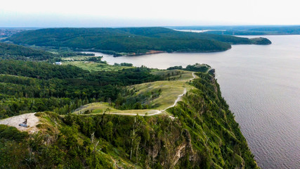 Obraz premium Arial view of Zhiguli mountains with green trees and Volga river in Samarskaya Luka national park during summer evening, Samara region, Russia