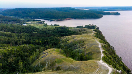 Arial view of Zhiguli mountains with green trees and Volga river in Samarskaya Luka national park during summer evening, Samara region, Russia
