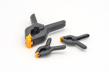 Obraz premium Black plastic clamps. Set of small and big size. Clamping equipment for handicraft, joinery and photography. White background.