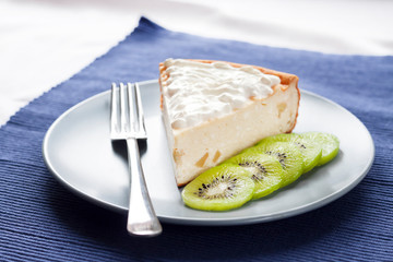 Homemade cottage cheese and semolina cake with kiwi fruit and cream on a plate