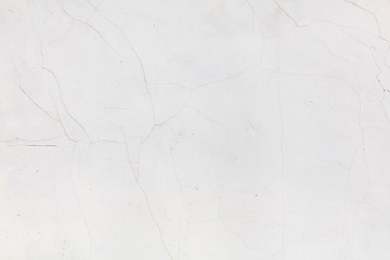 Naklejka premium White wall with cracked plaster as abstract background
