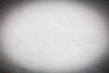 White wall with cracked plaster as abstract background