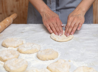 Girl rolls the dough in the kitchen