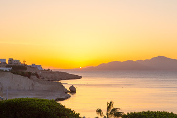 Sunrise over the red sea. Beautiful bright sky with sun rays and morning clouds. Sea and boats....