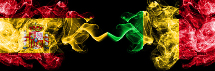 Spain vs Mali smoky mystic flags placed side by side. Thick colored silky smokes flag of Spanish and Mali