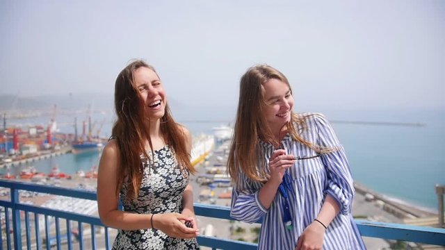 Two attractive women chatting and laughing against the docks