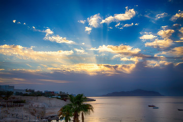Sunrise over the red sea. Beautiful bright sky with sun rays and morning clouds. Sea and boats....