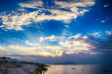 Sunrise over the red sea. Beautiful bright sky with sun rays and morning clouds. Sea and boats....