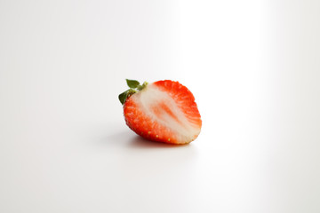 half red strawberry on a light white background close-up