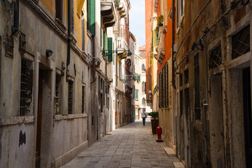 Fototapeta na wymiar View of the city narrow street in a sunny day in Venice, Italy