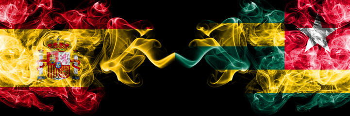 Spain vs Togo, Togolese smoky mystic flags placed side by side. Thick colored silky smokes flag of Spanish and Togo, Togolese