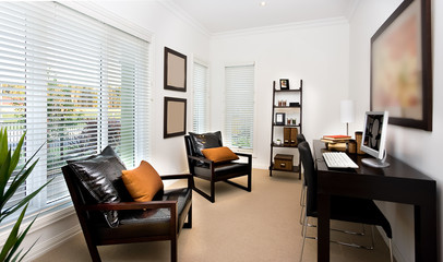 Modern work room interior decorated using dark color furniture and wooden materials in a luxury house