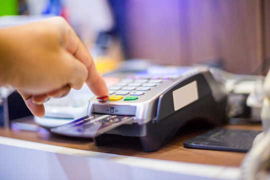Hand put credit card In slot and press the button of credit card reader.