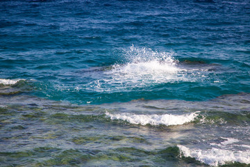 Blue clear water. Beautiful blue sea wave photograph close up. Beach vacation at sea or ocean. Background to insert images and text. Tourism, travel. Big wave with a white hat