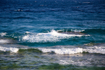 Blue clear water. Beautiful blue sea wave photograph close up. Beach vacation at sea or ocean. Background to insert images and text. Tourism, travel. Big wave with a white hat