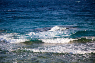 Blue clear water. Beautiful blue sea wave photograph close up. Beach vacation at sea or ocean. Background to insert images and text. Tourism, travel. Big wave with a white hat