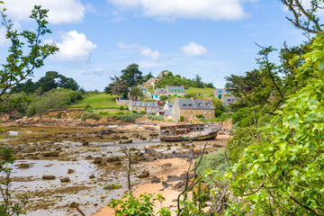 Fototapeta premium île de bréhat, ses maisons en pierre, plage à marées basse et un bateau échoué, côtes d'amor, Bretagne