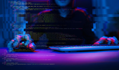 Hacker working with computer in dark room with digital interface around. Image with glitch effect.