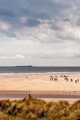 Fototapeta na wymiar Alnmouth Beach with people walking