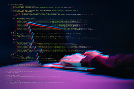 Hacker working with laptop in dark room with digital interface around. Image with glitch effect.