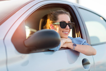 Happy woman driving a car and smiling