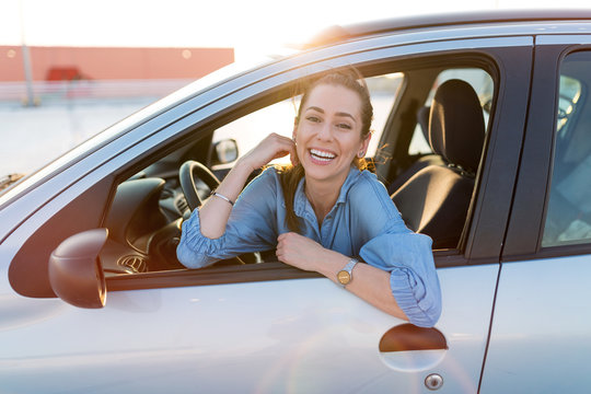 Happy Woman Driving A Car And Smiling