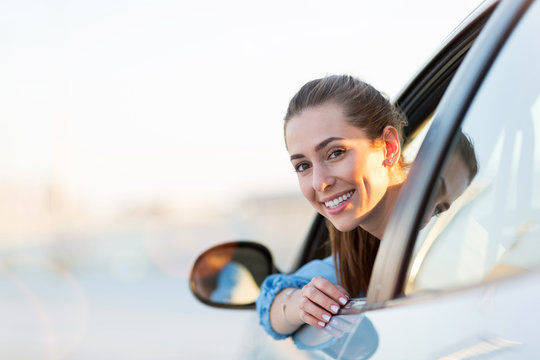 Happy woman driving a car and smiling