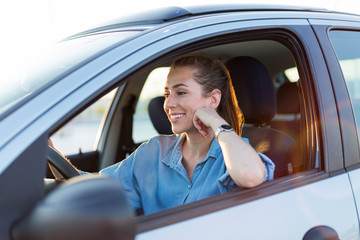 Happy woman driving a car and smiling