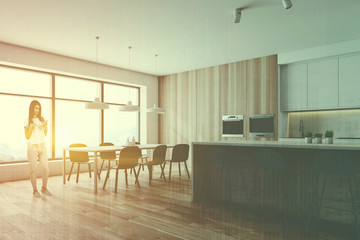 Woman in wooden kitchen with island
