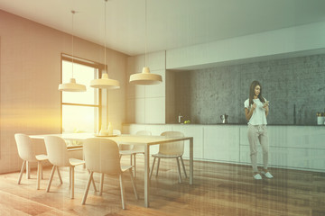 Woman in concrete kitchen with table