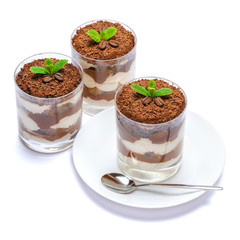 Classic tiramisu dessert in a glass on plate with spoon isolated on a white with clipping path