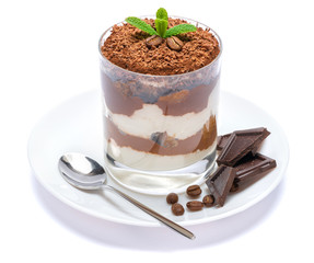 Classic tiramisu dessert in a glass on plate with spoon isolated on a white with clipping path