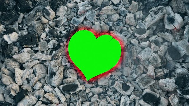 Paper heart burns in fire and turns to dust. Symbol of Burnout relationship, conceptual footage with green screen, easy replacement for any image