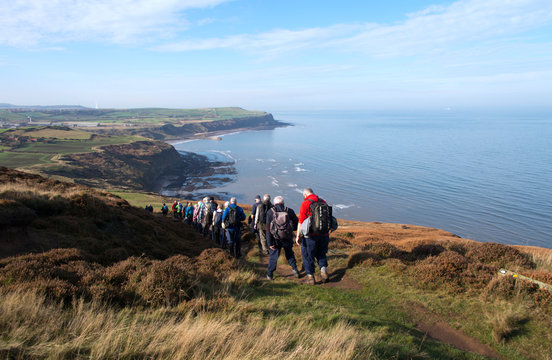 Group of walkers desending towards Hummersea Bay on the Cleveland Way, Yorkshire England