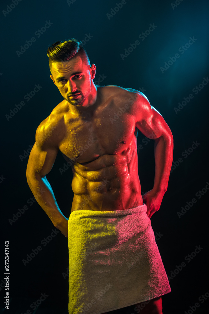 Wall mural man with a towel after a shower. press abs on a man belly. pumped up muscles. sport.