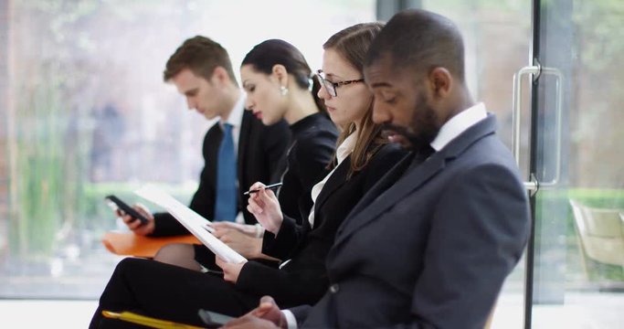 4K Diverse corporate job applicants waiting to be seen at job interview. Slow motion.