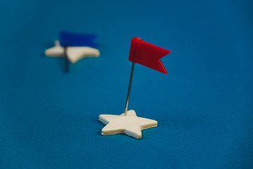 wooden stars and one red on a blue background with a red flag