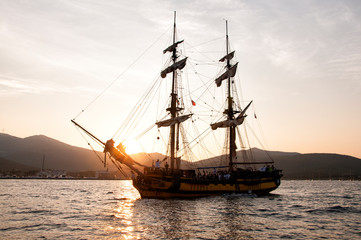 Fototapeta na wymiar Sailing boat in open sea at sunset