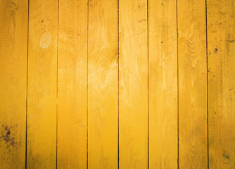 Yellow wall of boards. The texture of the wooden fence.