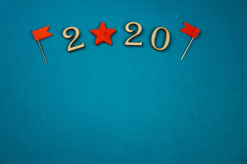 2020 number from wooden numbers on a blue background with scattered stars gears and flags around