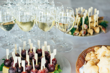 Catering services background with snacks,fruits canape and glasses of champagne or wine on bartender counter in restaurant